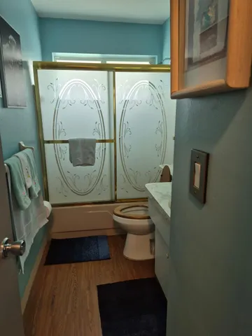 a bathroom with a toilet a sink and mirror