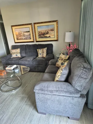 a living room with furniture and a painting on the wall