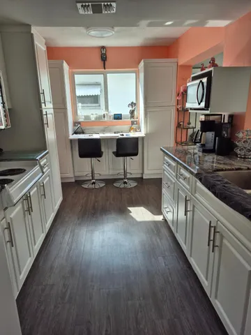 a view of a kitchen with furniture and wooden floor