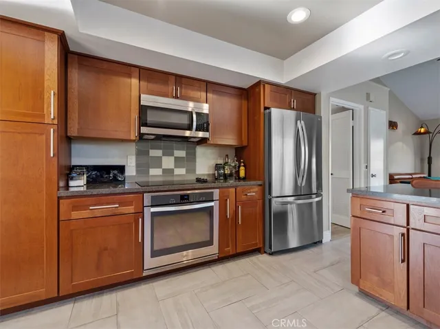 a kitchen with stainless steel appliances granite countertop a refrigerator sink and stove