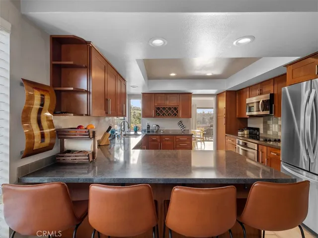 a kitchen with stainless steel appliances granite countertop a sink refrigerator and cabinets