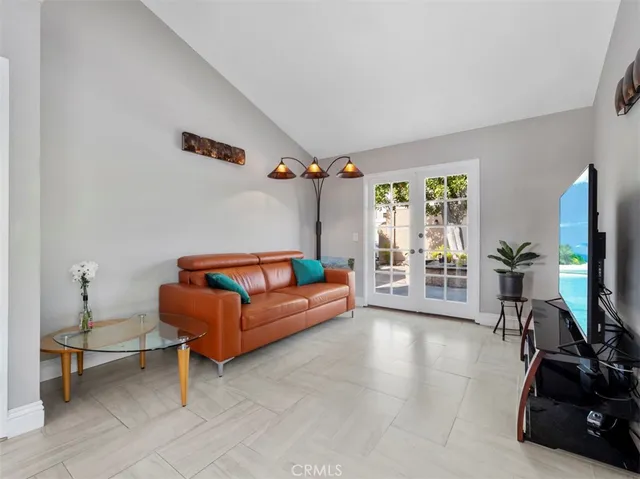 a living room with furniture a flat screen tv and a window
