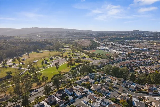 an aerial view of residential house with yard and mountain view in back