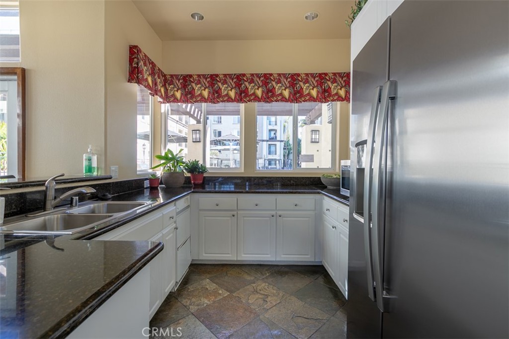 9293 Regents Road, Unit C303 La Jolla, CA 92037 - Photo 17 of 26 a kitchen with a sink window and cabinets