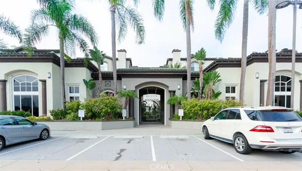 a car parked in front of a building with potted plants