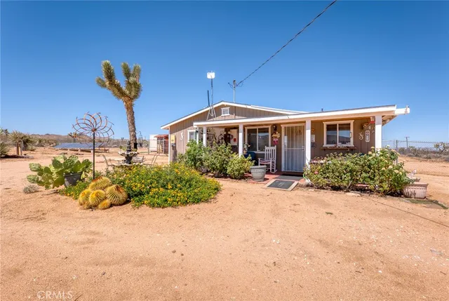 a front view of a house with a yard and potted plants