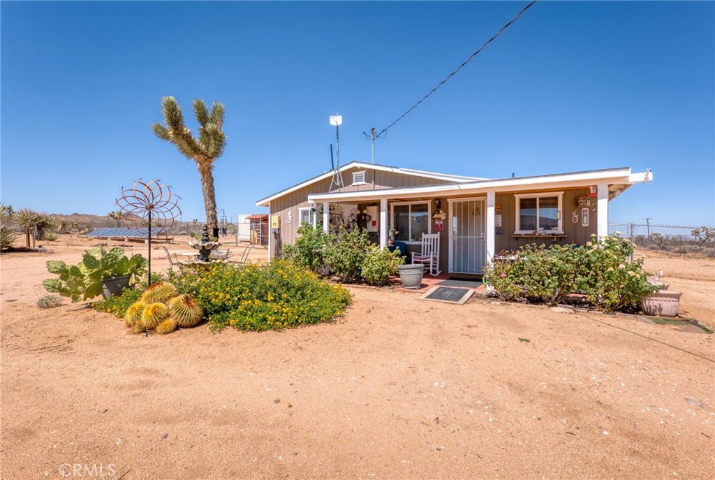 a front view of a house with a yard and potted plants