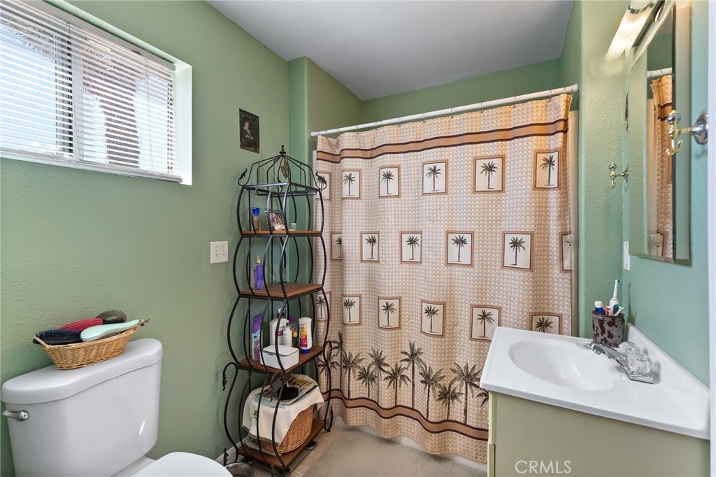880 Inca Trail Yucca Valley, CA 92284 - Photo 13 of 26 a bathroom with a sink a toilet and a shower curtain