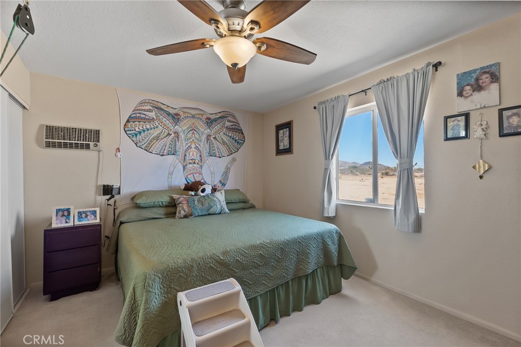 880 Inca Trail Yucca Valley, CA 92284 - Photo 15 of 26 a bedroom with a bed and a chandelier
