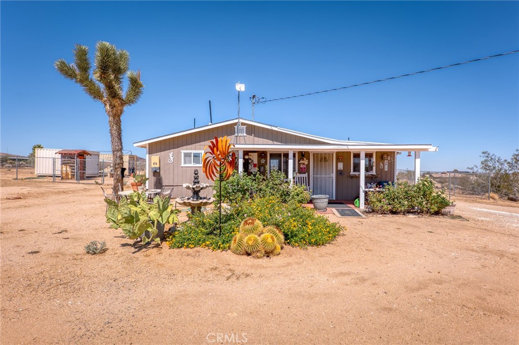 880 Inca Trail Yucca Valley, CA 92284 - Photo 4 of 26 a front view of a house with a yard and potted plants