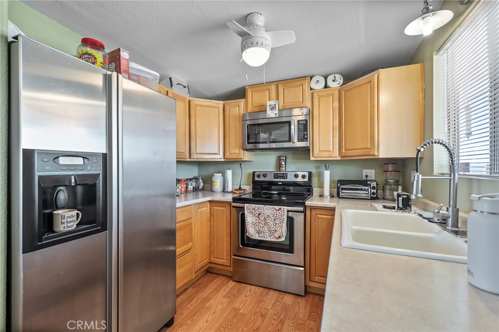 880 Inca Trail Yucca Valley, CA 92284 - Photo 6 of 26 a kitchen with stainless steel appliances granite countertop a refrigerator a stove and a sink