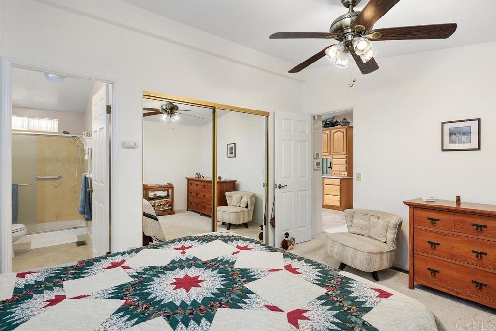 18218 Paradise Mountain Road Valley Center, CA 92082 - Photo 18 of 39 a bedroom with a bed a chandelier and a window