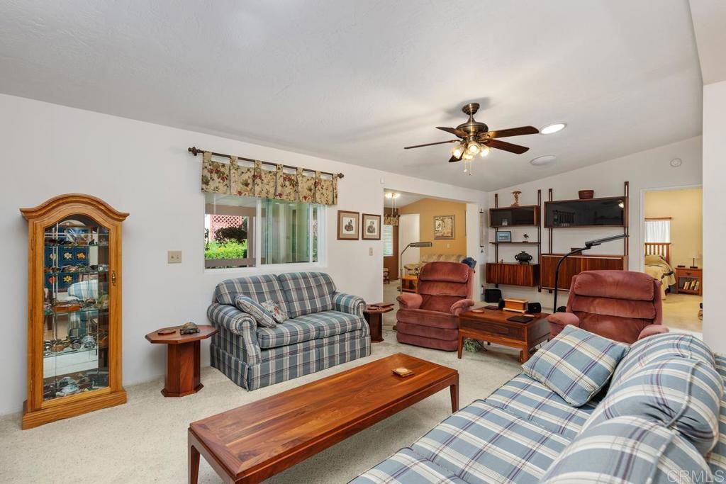 18218 Paradise Mountain Road Valley Center, CA 92082 - Photo 10 of 39 a living room with furniture a ceiling fan and a window