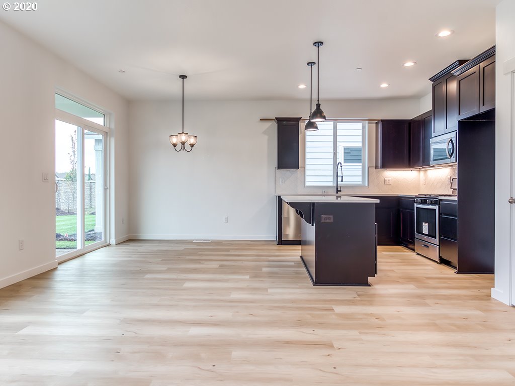 70 South 39th Drive Ridgefield, WA 98642 - Photo 3 of 24 a kitchen with kitchen island a counter top space a sink appliances and cabinets