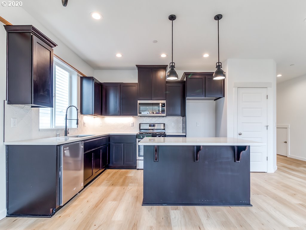 70 South 39th Drive Ridgefield, WA 98642 - Photo 6 of 24 a large kitchen with kitchen island a sink a stove and a wooden floors