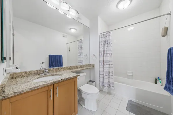 a bathroom with a granite countertop sink a toilet and shower
