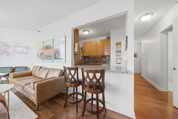 a living room with furniture wooden floor and a large window