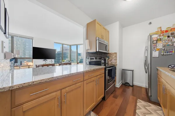 a kitchen with stainless steel appliances a stove microwave and a sink