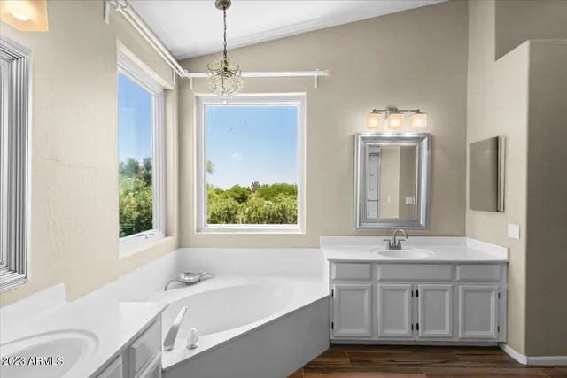 a bathroom with a tub sink and mirror