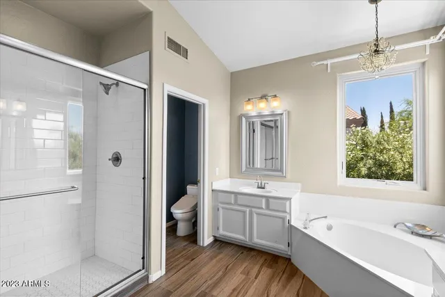 a bathroom with a tub a sink and a large mirror