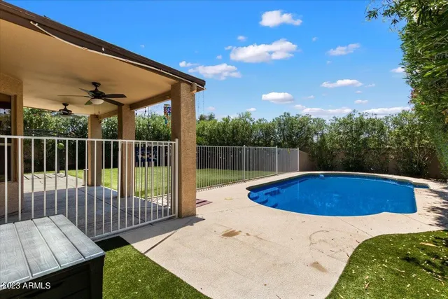 a view of backyard with swimming pool and outdoor seating