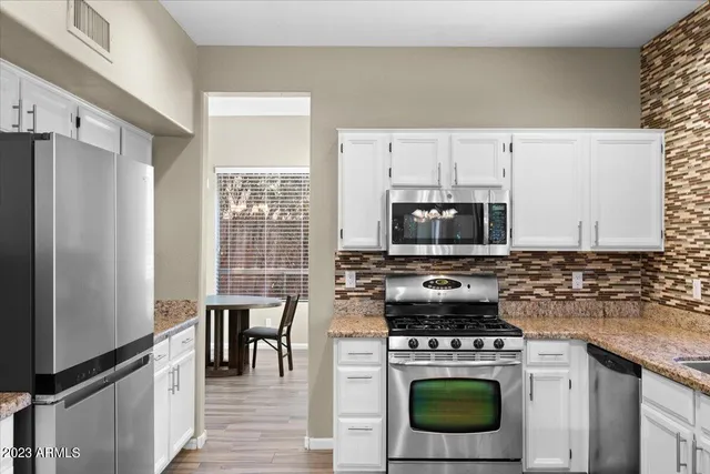 a kitchen with cabinets a steel appliances and a counter space
