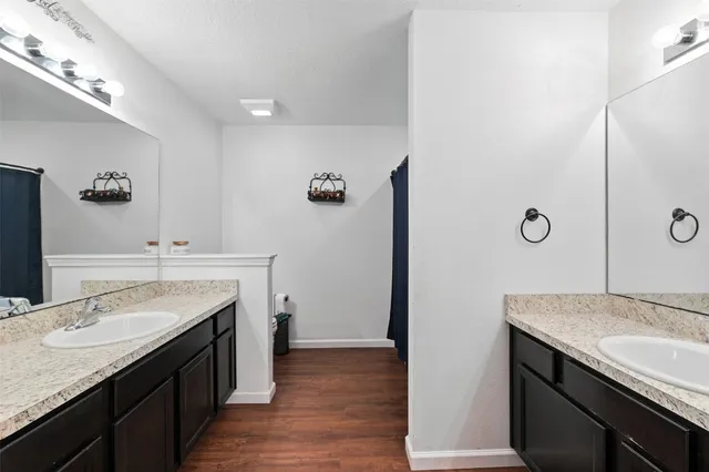 a bathroom with a granite countertop sink a mirror and a shower