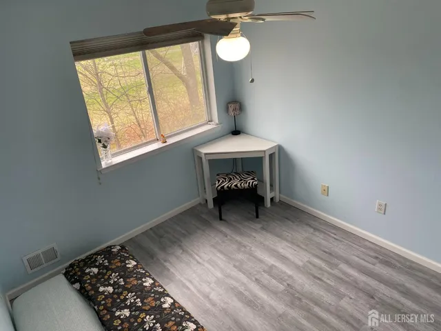 a view of a room with a window and wooden floor