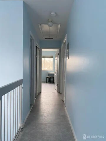 a view of a hallway to a livingroom with furniture
