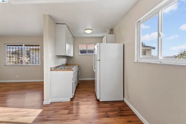 a view of kitchen with refrigerator and wooden floor