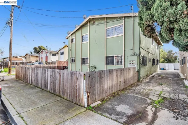 a view of a street with wooden fence
