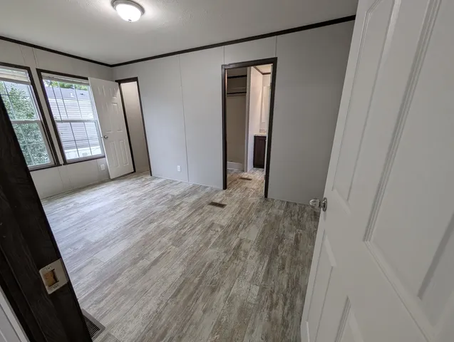 a view of hallway with window and wooden floor
