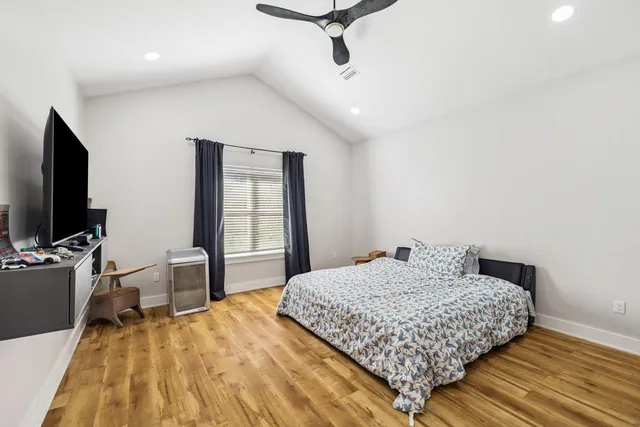 a bedroom with a large bed and a flat tv screen on a dresser
