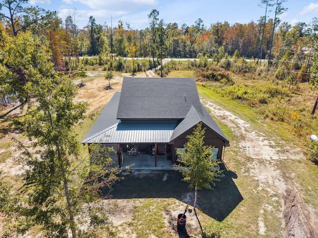 a view of a house with a yard and large trees