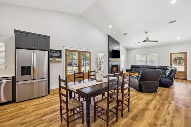 a living room with furniture a wooden floor and a refrigerator