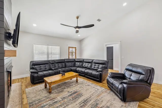 a living room with furniture a flat screen tv and a window