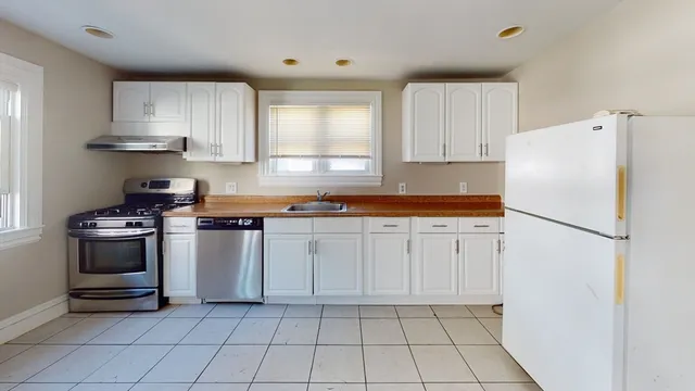 a kitchen with white cabinets and white appliances