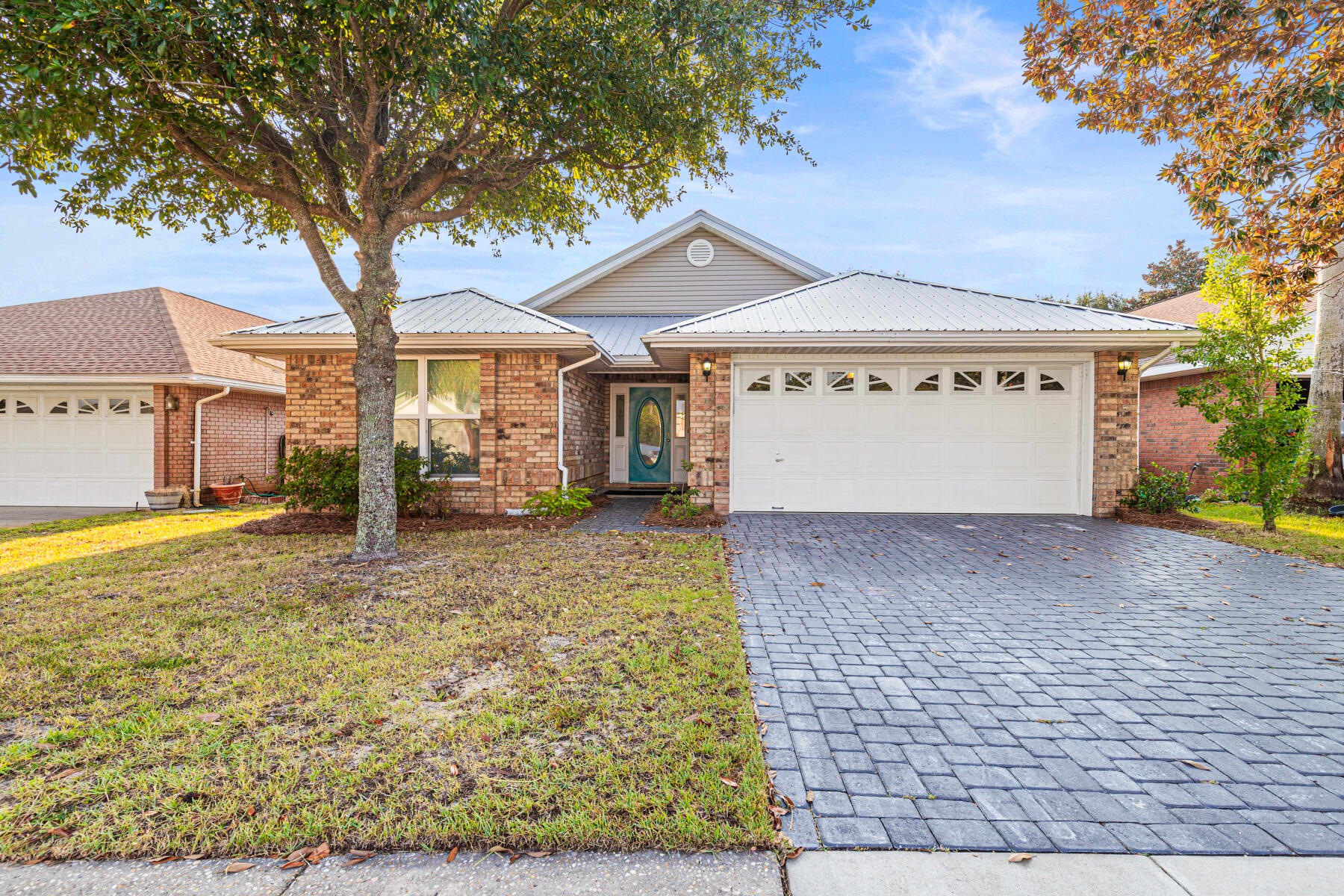 4666 Sunsail Circle Destin, FL 32541 - Photo 2 of 41 a view of a white house with a large tree and wooden fence