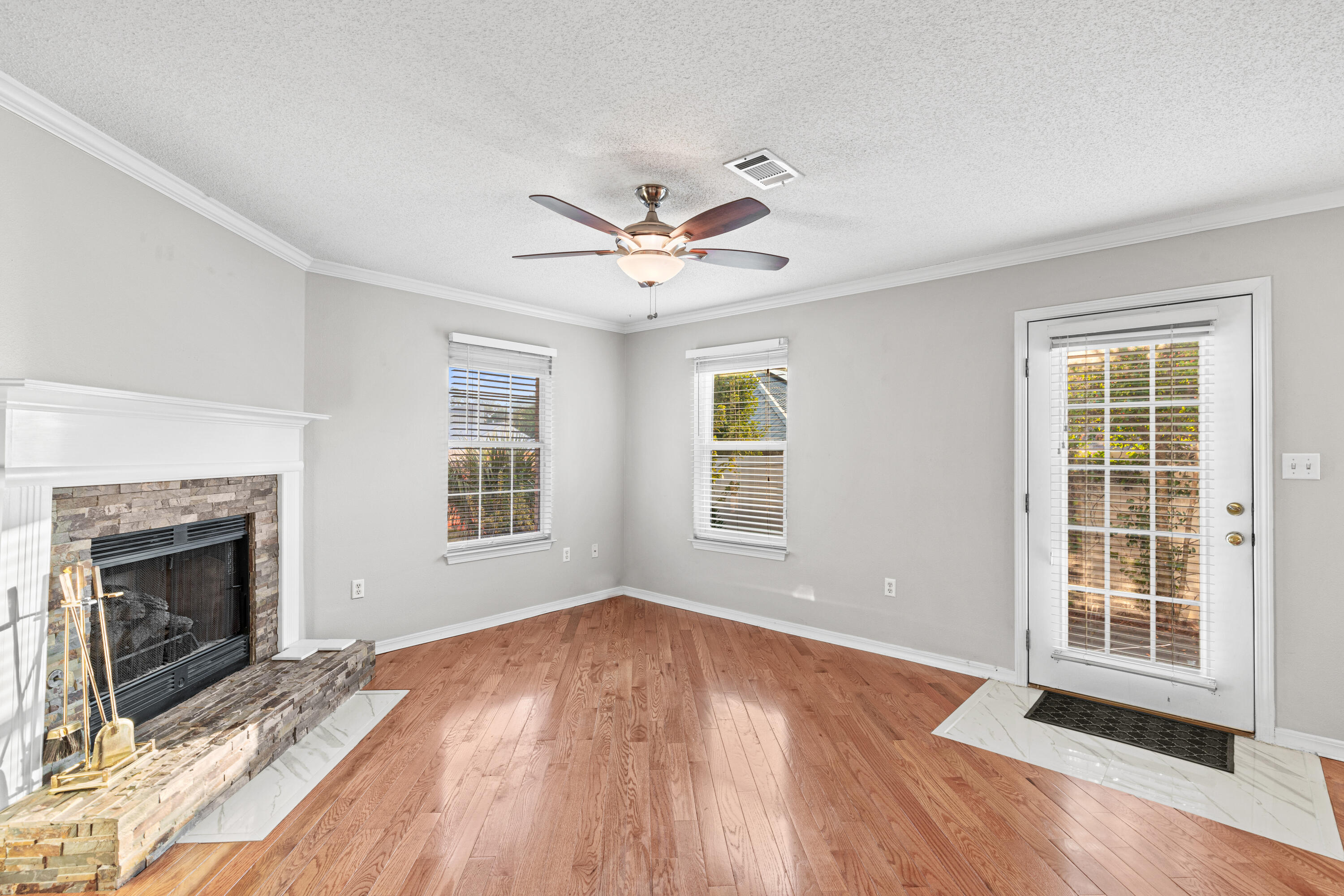 4666 Sunsail Circle Destin, FL 32541 - Photo 23 of 41 an empty room with wooden floor fireplace and windows
