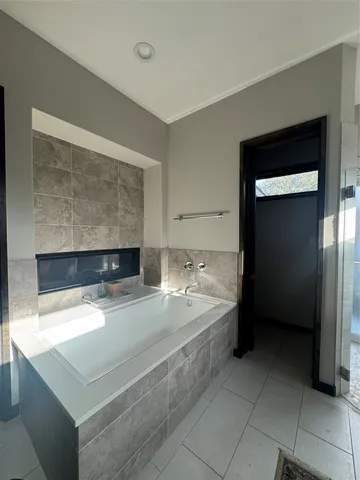 a large bathroom with a granite countertop double vanity sink a bathtub and a shower