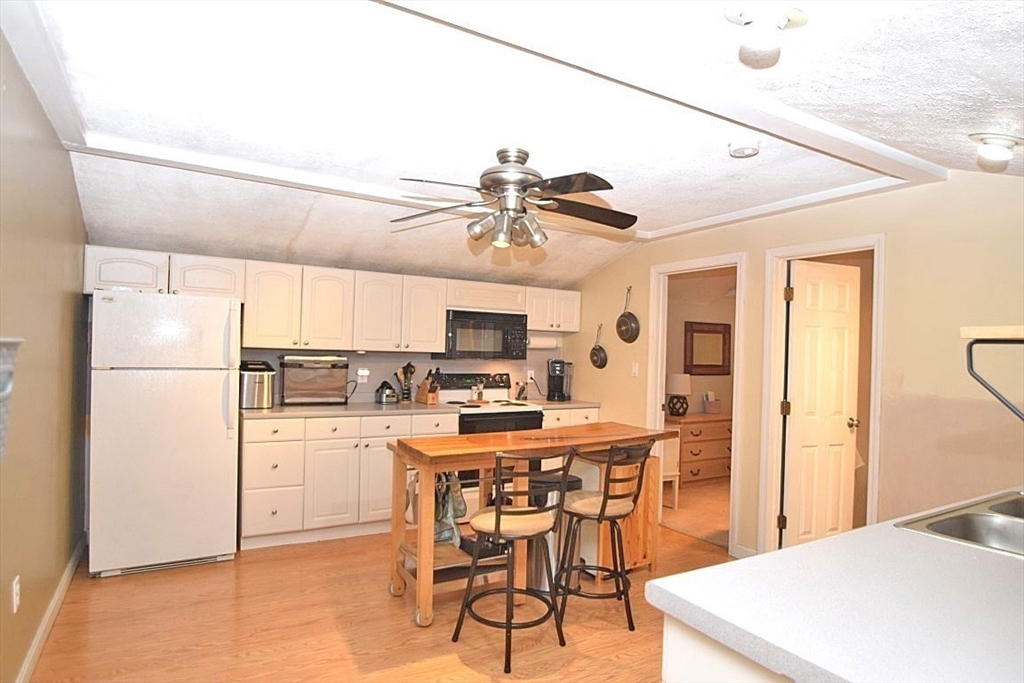 17 Kalmia Road Holbrook, MA 02343 - Photo 5 of 27 a kitchen with a table a refrigerator a stove a dining table and chairs