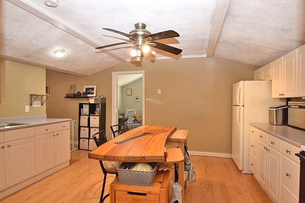17 Kalmia Road Holbrook, MA 02343 - Photo 8 of 27 a kitchen with stainless steel appliances a dining table chairs refrigerator and sink