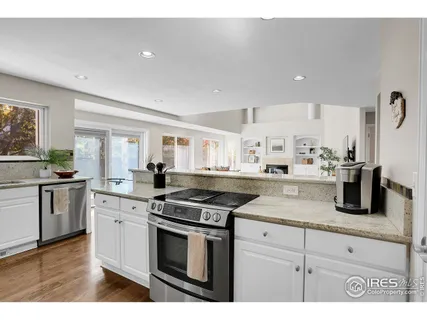 a kitchen with granite countertop white cabinets and stainless steel appliances