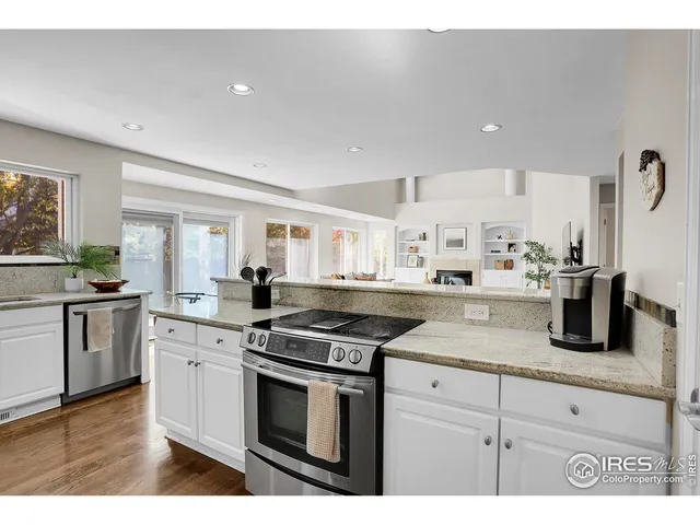a kitchen with granite countertop white cabinets and stainless steel appliances