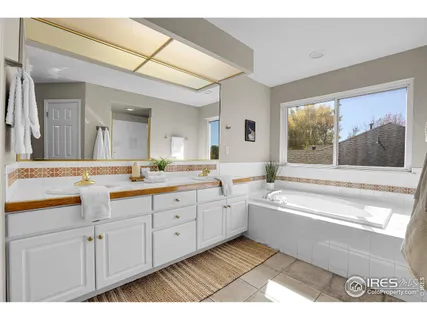 a spacious bathroom with a granite countertop sink mirror and a bathtub