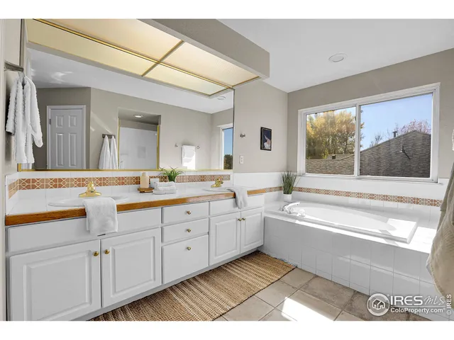 a spacious bathroom with a granite countertop sink mirror and a bathtub