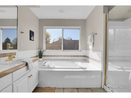 a bathroom with a tub sink and mirror