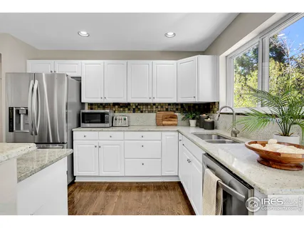 a kitchen with stainless steel appliances granite countertop a sink a stove a refrigerator a counter space and cabinets