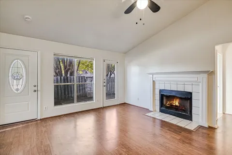 wooden floor fireplace and windows in an empty room