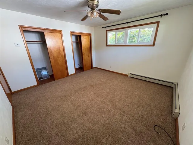 an empty room with windows and closet